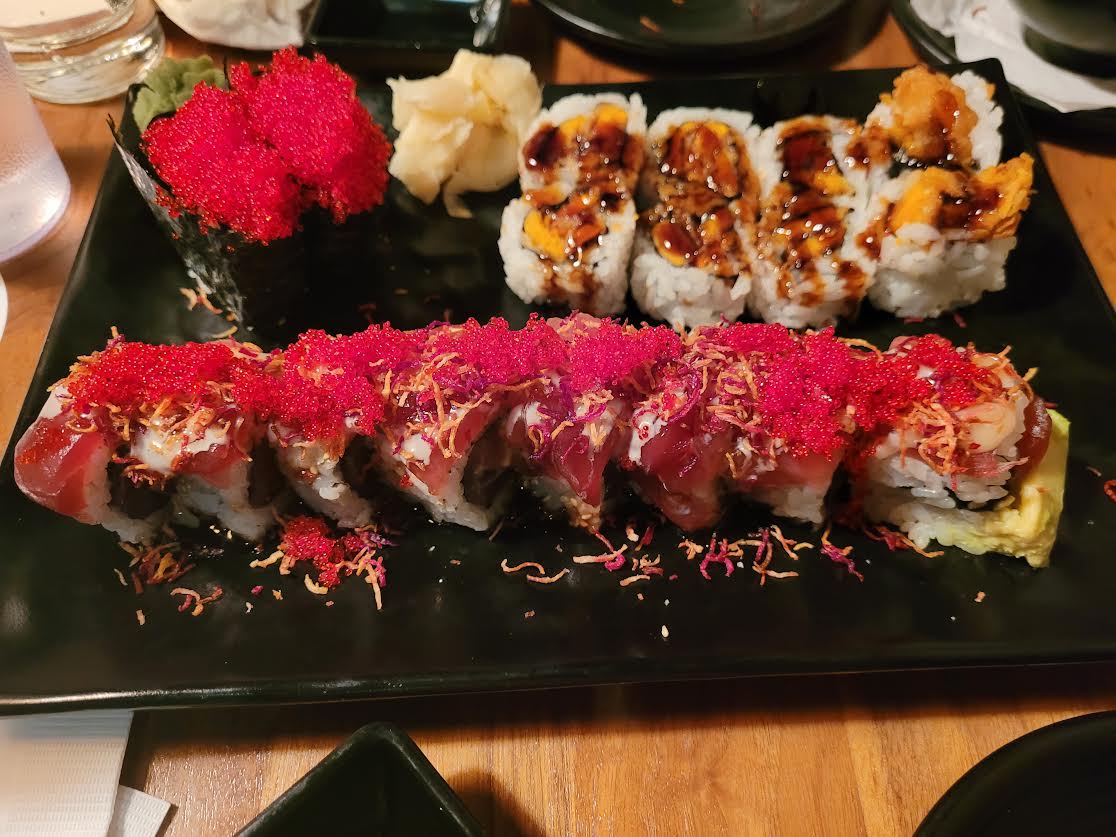 two ikura sushi, a sweet potato tempura role, and an elaborate sushi roll with tuna, avacado, and shiny red ikura
